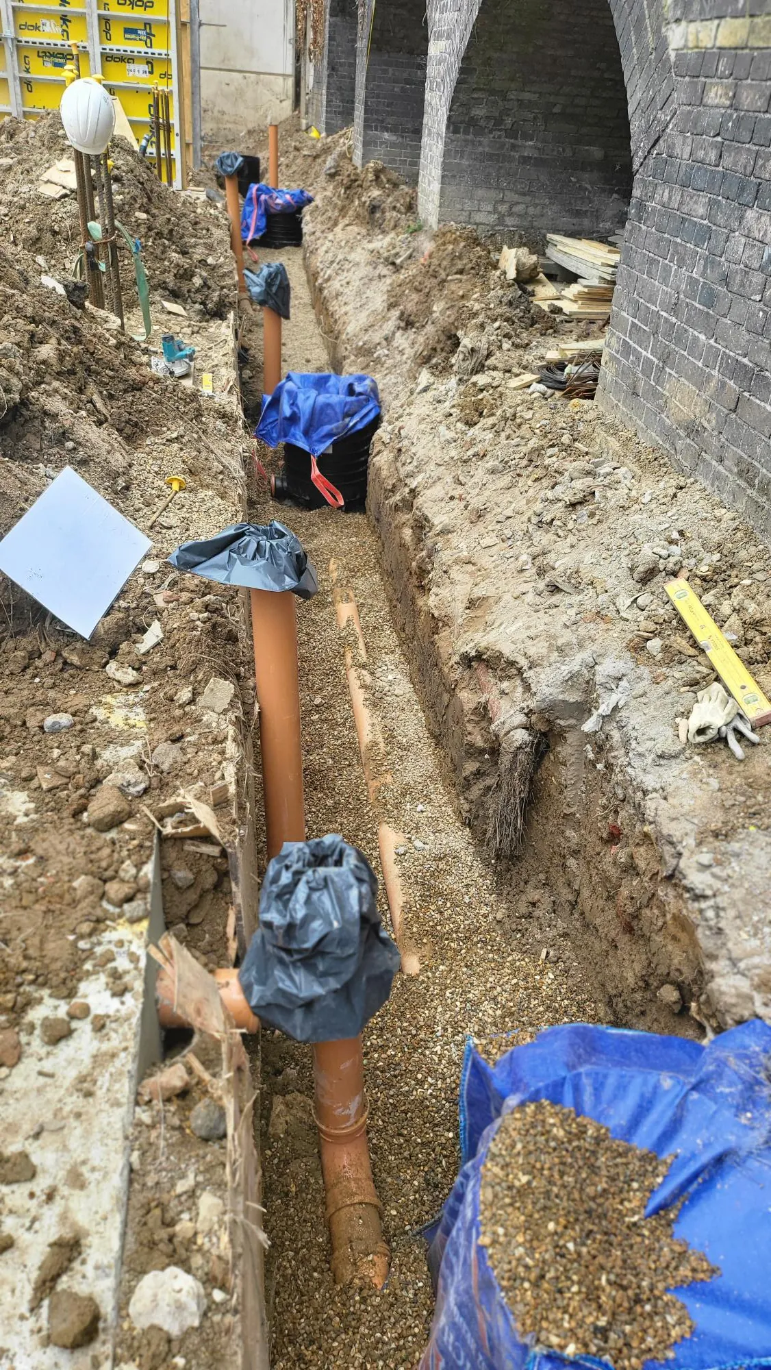 Drainage pipes laid on gravel along the arches