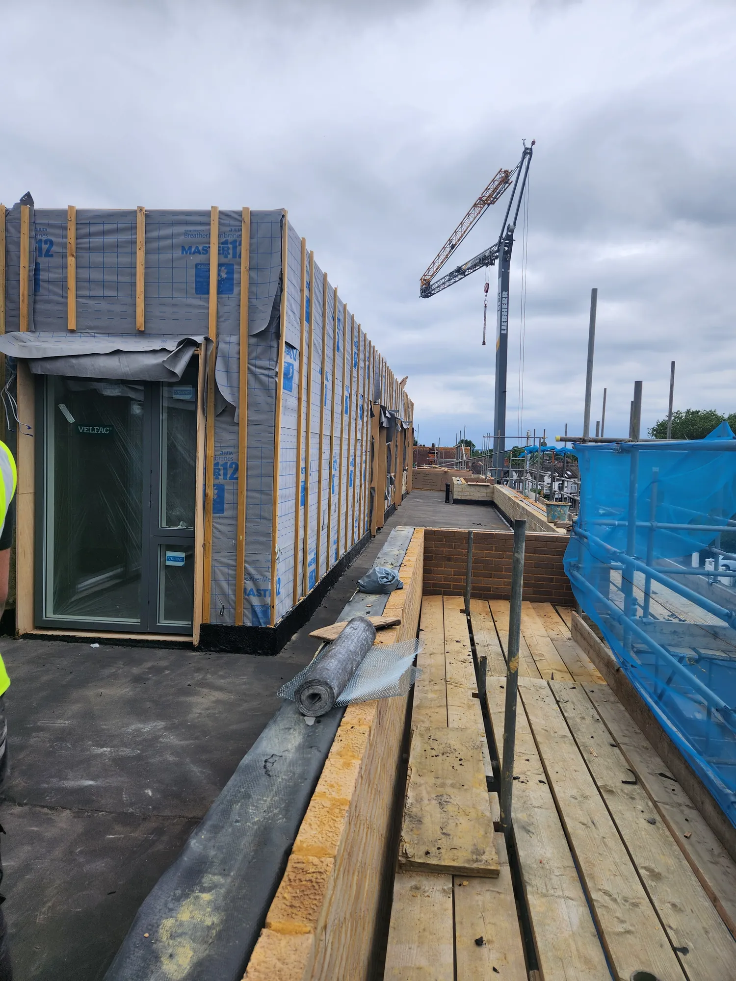The top floor wrapped in membrane, with the new doors in