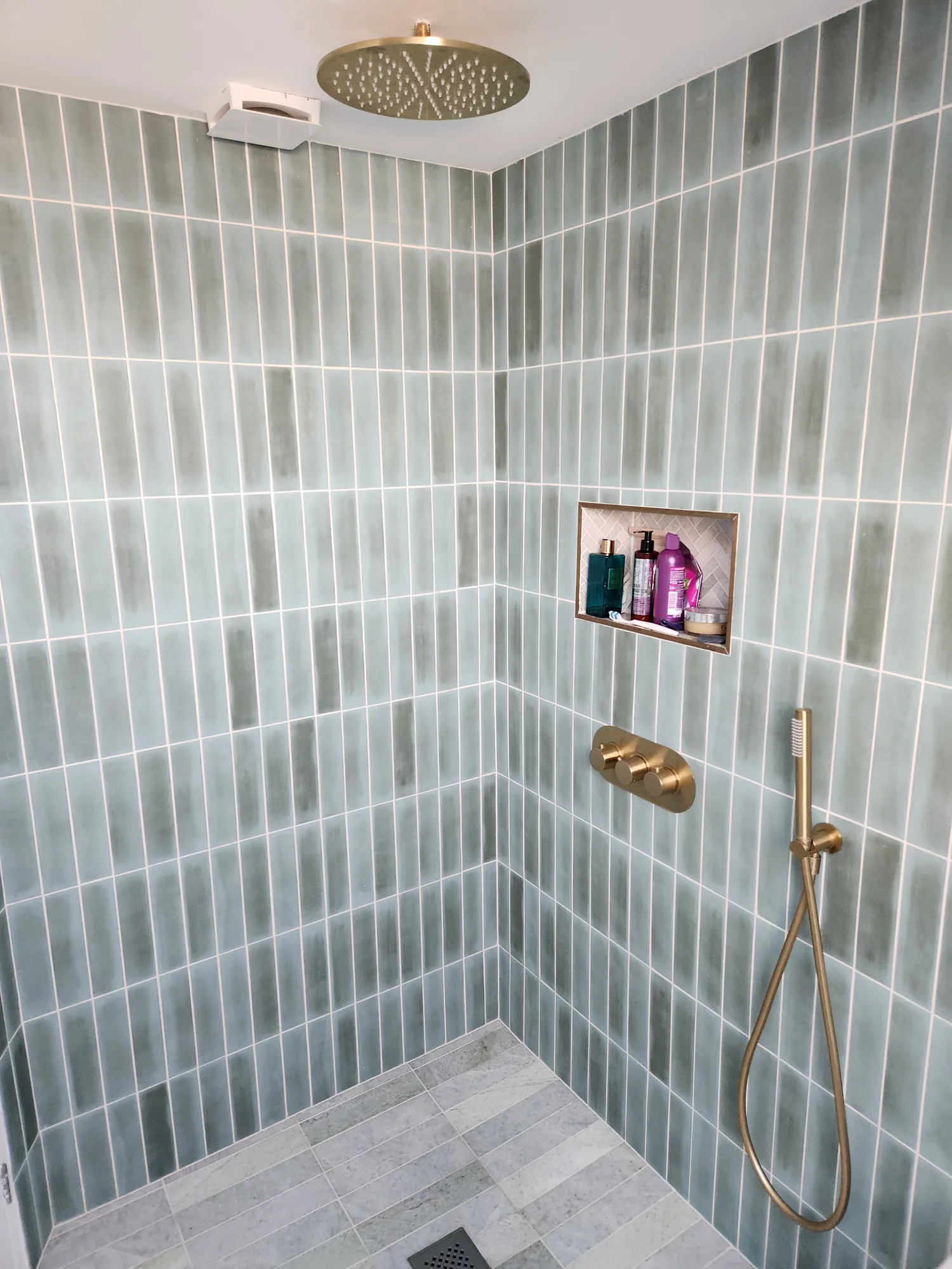 Walk-in shower with a brass rainfall head