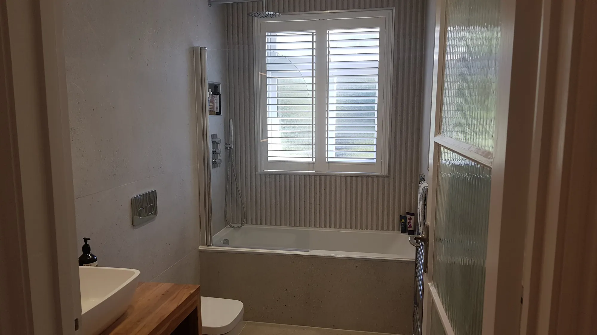 Family bathroom with a bath and stone-effect tiling