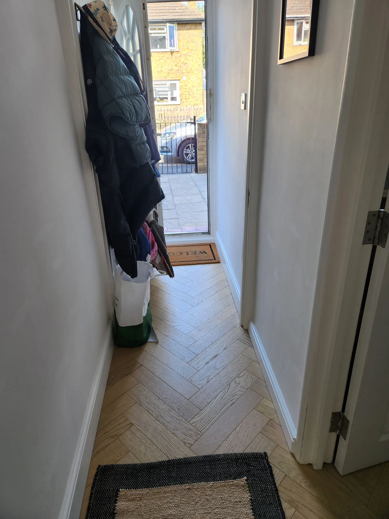 Hallway with herringbone flooring to the front door