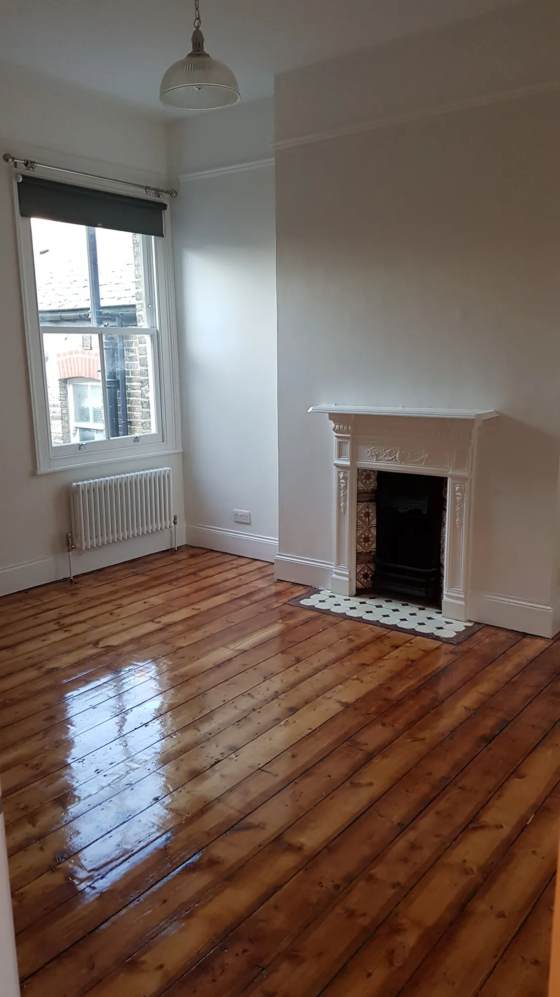 Living room with the original fireplace and stripped floorboards
