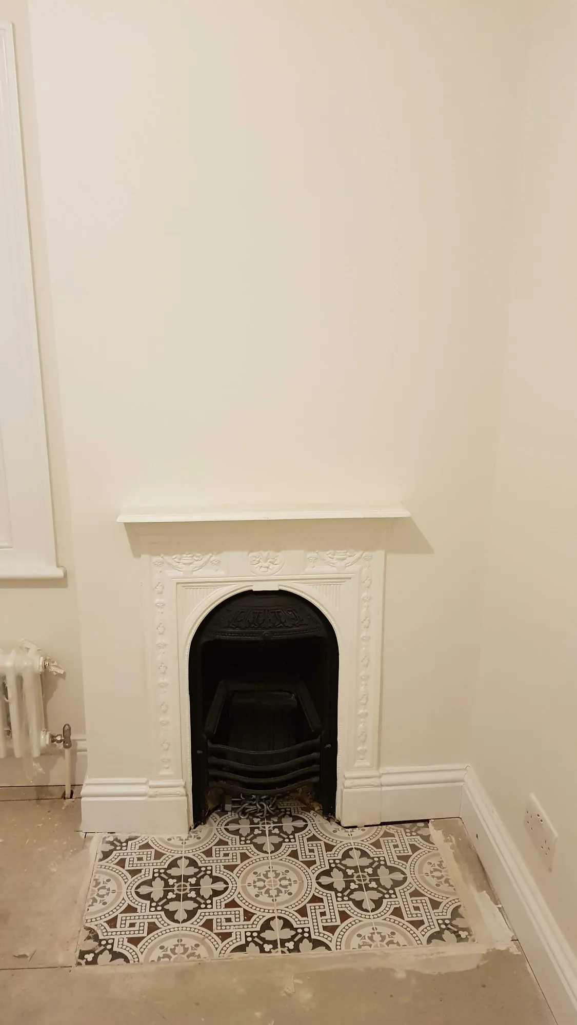 Cast iron fireplace with a patterned tiled hearth