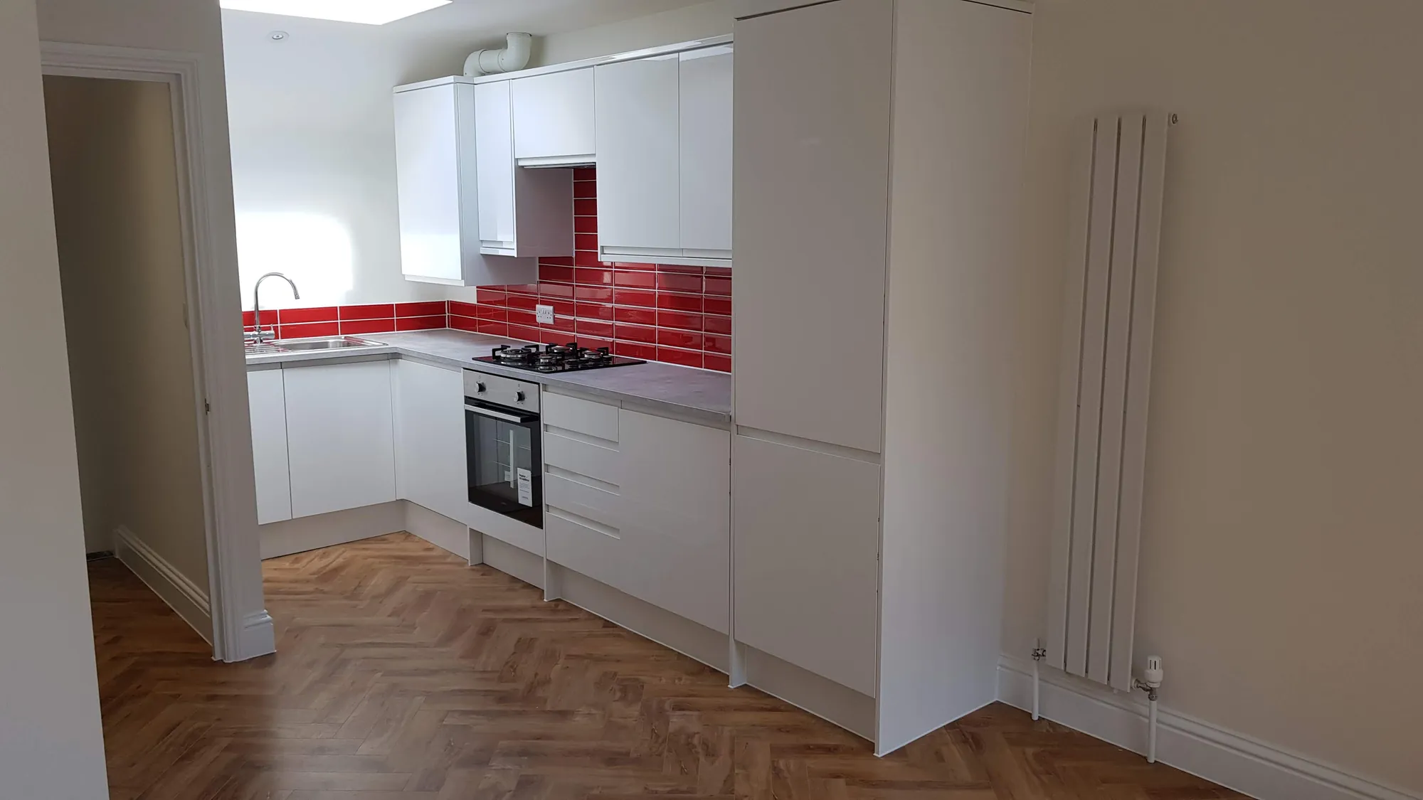 Kitchen with a red tiled splashback